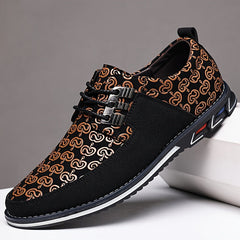 A black casual shoe with a patterned upper, lace-up closure, and a thick rubber sole.
