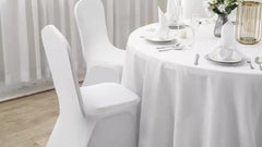 White stretch spandex chair covers fitted over dining chairs at a banquet table.