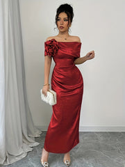 A woman wears a red off-shoulder bodycon maxi dress featuring a large floral accent and ruching.