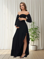 A pregnant woman wears a black off-shoulder maternity dress with lantern sleeves and a ruffled hem.