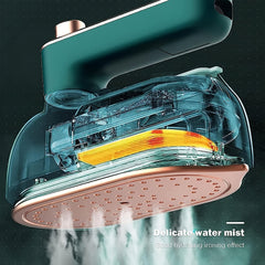 A portable handheld steam iron with a green handle and a copper-colored soleplate emitting mist.
