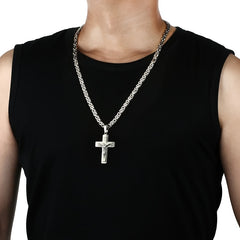 A man wears a silver-toned stainless steel crucifix pendant on a flat U-shaped chain.