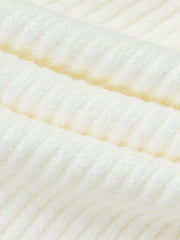 A close-up view of a white knitted midi skirt featuring a soft, ribbed texture.
