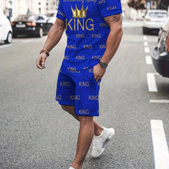 A man wears a blue short-sleeve t-shirt and shorts set featuring an all-over gold King print.
