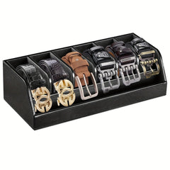 A black leather organizer box containing six rolled belts with various buckle styles.