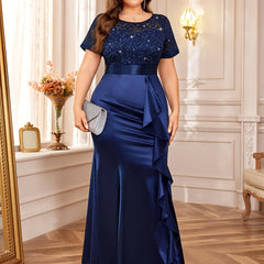 A plus size navy blue mermaid dress with a sequined lace bodice, short sleeves, and ruffled trim.