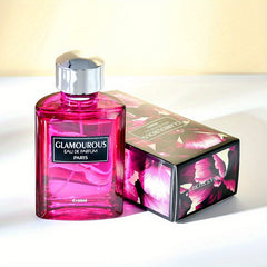 A bottle of Glamourous Eau de Parfum with a pink liquid and its matching floral box.
