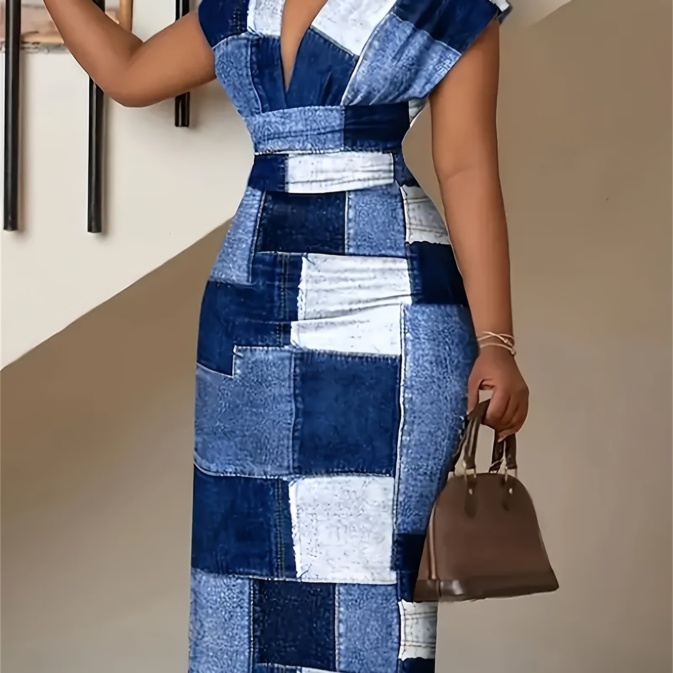 A woman wears a slim-fit, V-neck midi dress featuring a blue and white denim-style plaid print.
