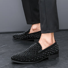 A pair of black slip-on loafers for men featuring an all-over studded design and rubber soles.