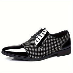 A black and white lace-up Oxford dress shoe with a glossy toe cap and patterned side panels.