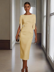 A woman wears a pale yellow midi-length bodycon dress with half sleeves and pearl detailing.