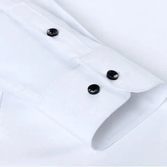 A close-up of a white long-sleeved shirt cuff featuring two black buttons.