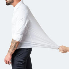 A man wears a white long-sleeved button-down shirt made of highly stretchable fabric.