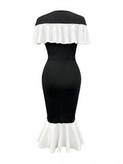A black bodycon dress with a white ruffled off-shoulder neckline and a white fishtail hem.