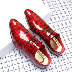 A pair of glossy red ripple-patterned men's lace-up dress shoes with pointed toes.