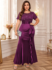A plus size purple floor-length dress with a sequined lace bodice and a ruffled mermaid hem.