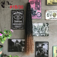 A long, deep wave crochet hair extension with an ombre color transition from black to light brown.