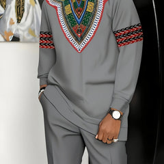 A man wears a grey long-sleeved African-inspired suit featuring a colorful patterned chest design.