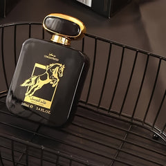 A black rectangular bottle of Qaed Al Fursan perfume with a gold horse emblem in a wire basket.