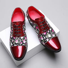 Men's floral print lace-up dress shoes with a glossy red pointed toe and rubber sole.