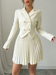 A woman wears a cream-colored double-breasted blazer with a matching pleated mini skirt.