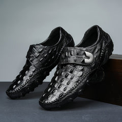 Black leather loafers with a crocodile texture, a hook and loop strap, and a rubber sole.