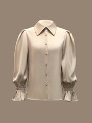 A beige long-sleeved button-down shirt with a lapel collar and ruffled cuffs.