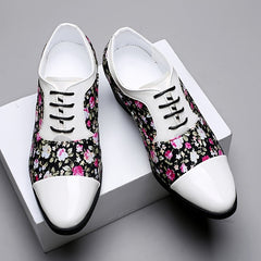 Men's floral print lace-up dress shoes with white pointed toe caps and rubber soles.