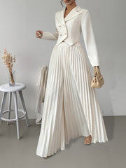 A woman wears an elegant cream-colored suit featuring a double-breasted blazer and pleated pants.