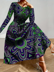 A woman wears a long-sleeved, A-line maxi dress featuring a purple and green dot-art floral pattern.