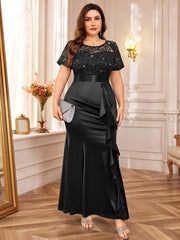 A plus-size black mermaid gown featuring a sequined lace bodice and a ruffled satin skirt.
