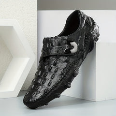 Black leather loafers with a crocodile texture, a hook and loop strap, and a rubber sole.