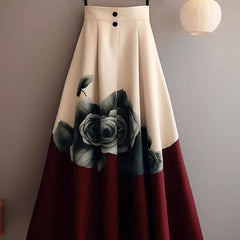 A beige and red A-line midi skirt featuring a large dark floral print and two front buttons.