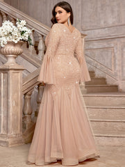 A plus size champagne sequin lace gown with a V-neck, bell sleeves, and a mermaid tulle hem.