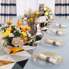 A table setting featuring clear plastic plates with gold rims and wrapped gold plastic silverware.