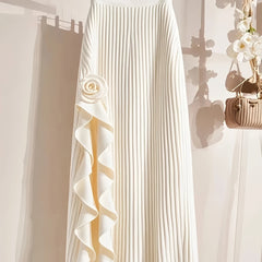 An elegant white pleated midi skirt featuring a decorative rose applique and ruffled side detail.