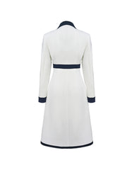 A white midi-length dress with a lapel collar and navy blue color-block trim on the waist and cuffs.