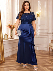 A plus-size navy blue mermaid dress with a sequined lace bodice and a ruffled side detail.
