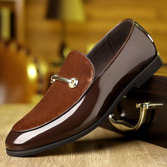 A brown slip-on loafer featuring a glossy finish, a suede-textured vamp, and a gold metal accent.