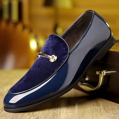 A navy blue slip-on loafer featuring a velvet vamp, patent leather sides, and a gold metal bit.