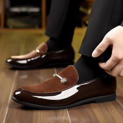 Men's brown slip-on loafers featuring a glossy finish, suede-textured vamp, and gold-tone hardware.