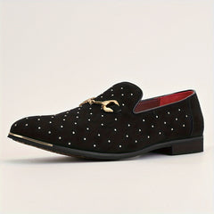 A black slip-on loafer with silver studs, a gold horsebit detail, and a red interior lining.
