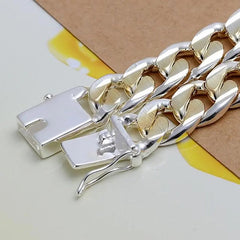 Close-up of the 925 Sterling Silver Solid 10mm Chain Bracelet for men and women, featuring silver and gold tones with a box clasp, displayed on a yellow and brown background—perfect as noble wedding jewelry or a fashionable birthday gift.
