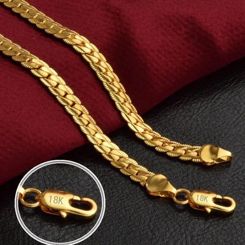 Two 6MM 925 sterling silver chains plated with 18K gold are displayed on red and black fabric. A close-up highlights the clasp, showcasing the purity and style of these trendy chain bracelet and necklace jewelry sets for women and men.
