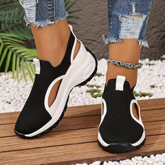 A pair of black and white breathable walking sneakers with cut-out sides and cushioned soles.