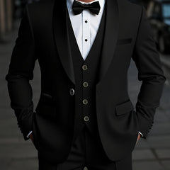 A man wearing a black three-piece suit with a shawl collar jacket, vest, and bow tie.