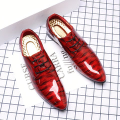 A pair of glossy red dress shoes with a ripple pattern, pointed toes, and black lace-up closures.