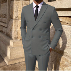 A man wears a solid grey double-breasted suit with a white shirt and black tie.