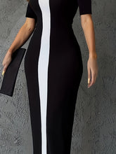 A woman wears a black bodycon midi dress featuring a vertical white stripe down the center.
