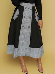 A person wears a black and grey plaid midi skirt featuring a button-down front and side pockets.